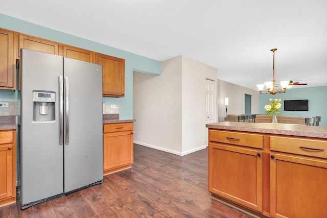 kitchen featuring stainless steel fridge with ice dispenser, open floor plan, dark wood-type flooring, hanging light fixtures, and an inviting chandelier