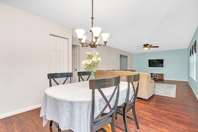 dining room with dark wood-style floors, ceiling fan with notable chandelier, and baseboards