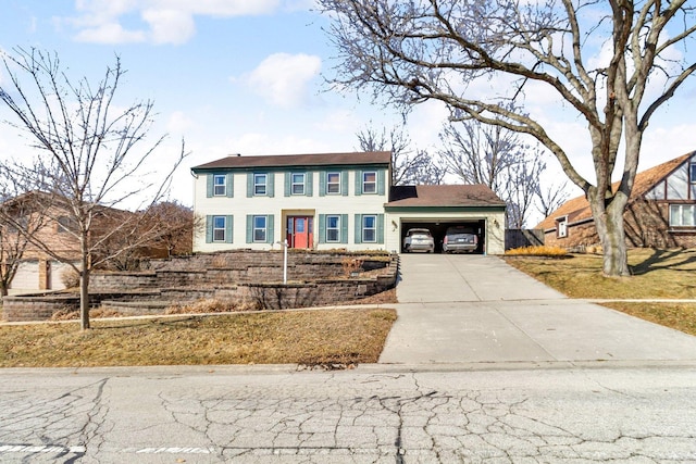 colonial-style house featuring a garage and concrete driveway