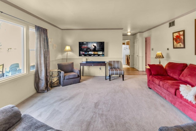 carpeted living room with ornamental molding and visible vents