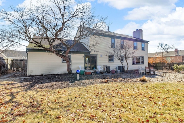 back of property featuring a patio, a chimney, and fence