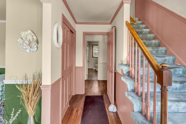 interior space with hardwood / wood-style floors, stairway, and crown molding