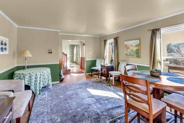 dining area featuring plenty of natural light, crown molding, stairway, and wood finished floors