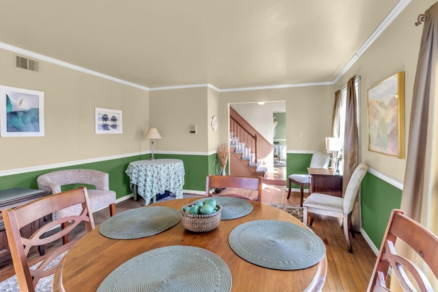 living area featuring visible vents, crown molding, stairway, and wood finished floors