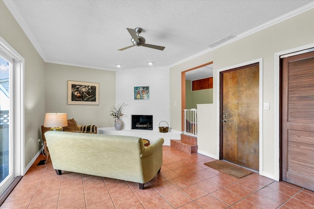 living room featuring light tile patterned floors, visible vents, ceiling fan, and ornamental molding