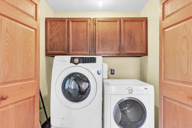 laundry area with separate washer and dryer, cabinet space, and a textured ceiling