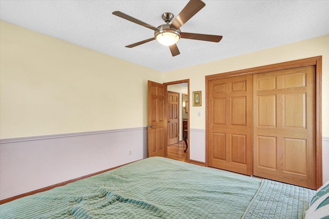 unfurnished bedroom with a closet, a textured ceiling, and ceiling fan