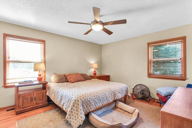 bedroom with visible vents, multiple windows, light wood-style floors, and a textured ceiling