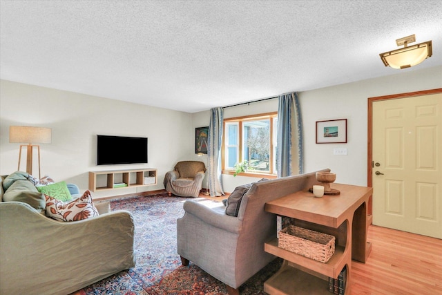 living room with light wood-style floors and a textured ceiling