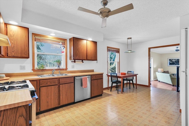 kitchen with light floors, dishwasher, ceiling fan, and a sink