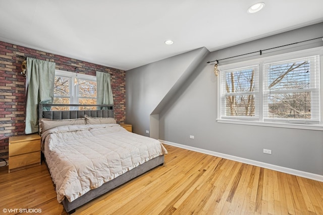 bedroom featuring hardwood / wood-style floors, multiple windows, and baseboards