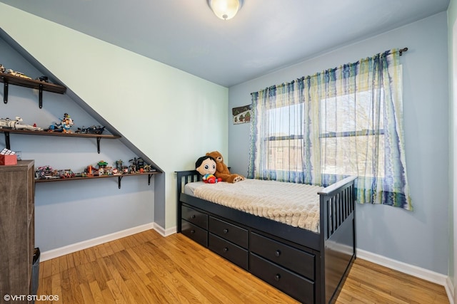 bedroom with baseboards and light wood finished floors