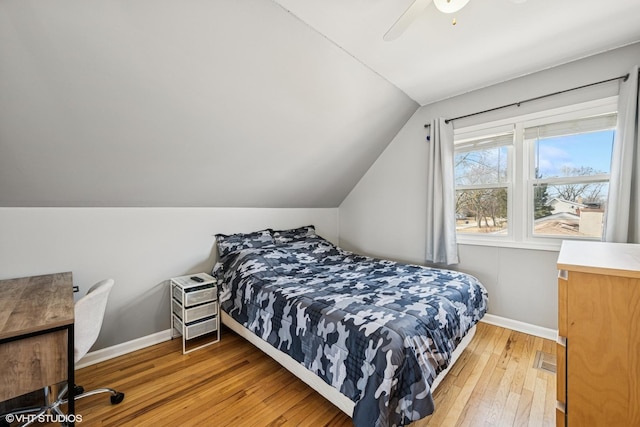 bedroom featuring a ceiling fan, vaulted ceiling, baseboards, and light wood-type flooring