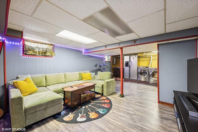 living area with wood finished floors, separate washer and dryer, and a paneled ceiling