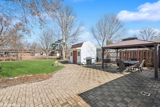 view of patio featuring a gazebo, area for grilling, fence, and an outdoor structure