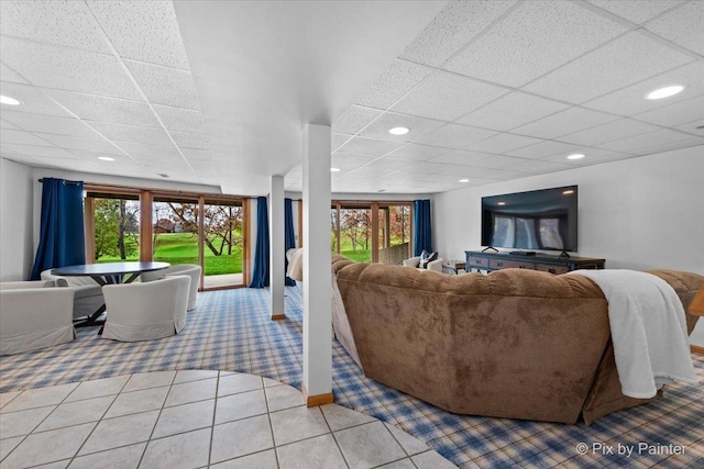 living area featuring tile patterned floors, a drop ceiling, plenty of natural light, and recessed lighting