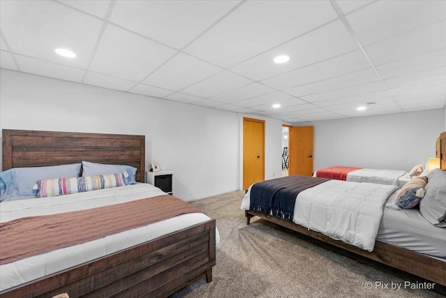 carpeted bedroom with recessed lighting and a paneled ceiling