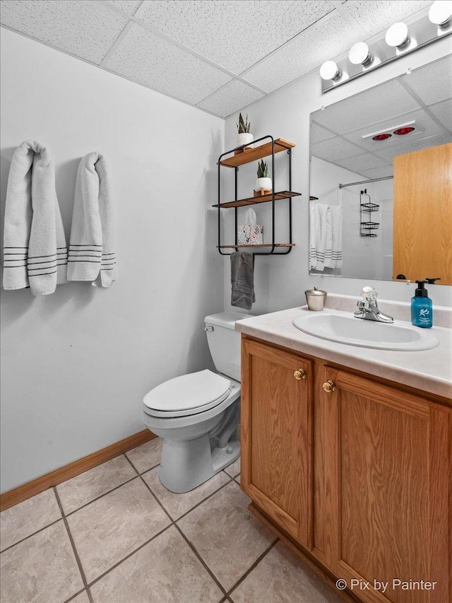 full bath featuring a drop ceiling, curtained shower, toilet, and vanity