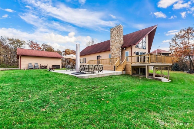 back of property with stairway, a lawn, a chimney, a deck, and a patio area