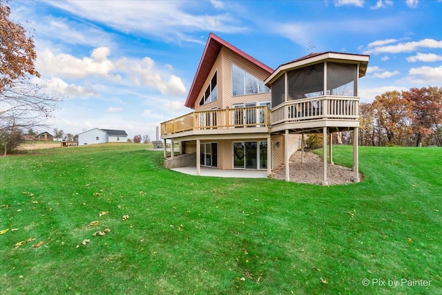 rear view of property with a patio area, a lawn, a sunroom, and a wooden deck