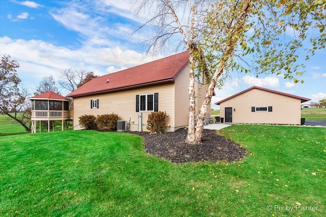 back of property featuring cooling unit, a lawn, and a sunroom