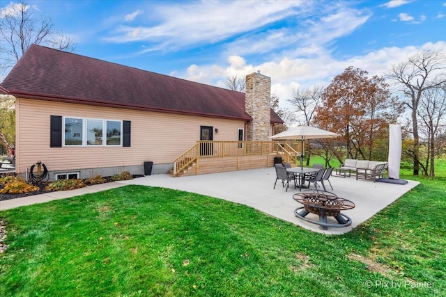 back of house with a wooden deck, a patio, a lawn, and a chimney