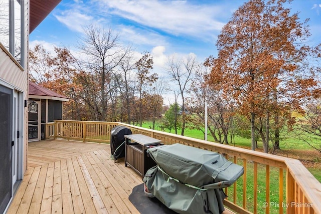 wooden deck with area for grilling and a yard