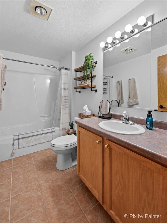 bathroom with tile patterned floors, shower / bath combo with shower curtain, toilet, a textured ceiling, and vanity