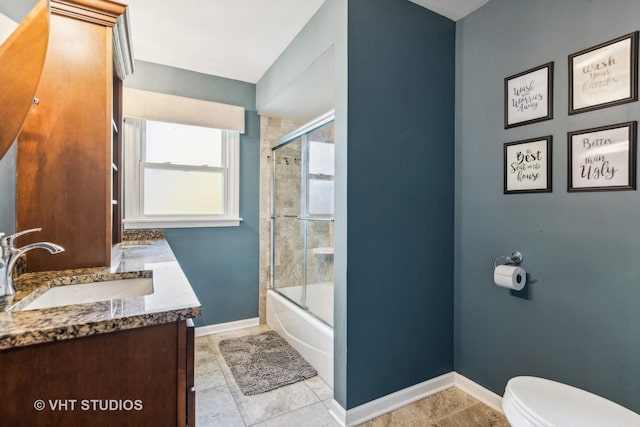 full bath featuring toilet, shower / bath combination with glass door, baseboards, and vanity