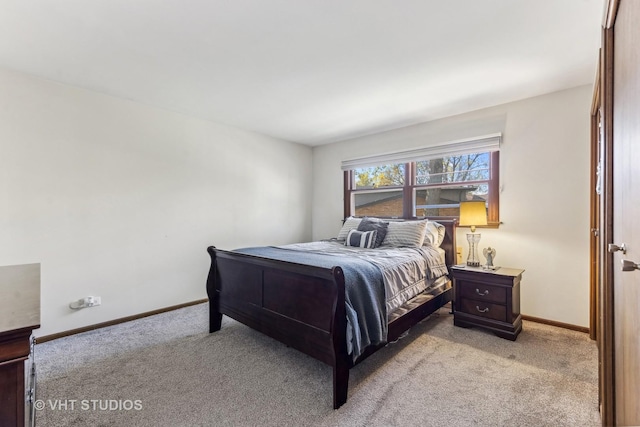 bedroom with baseboards and light colored carpet