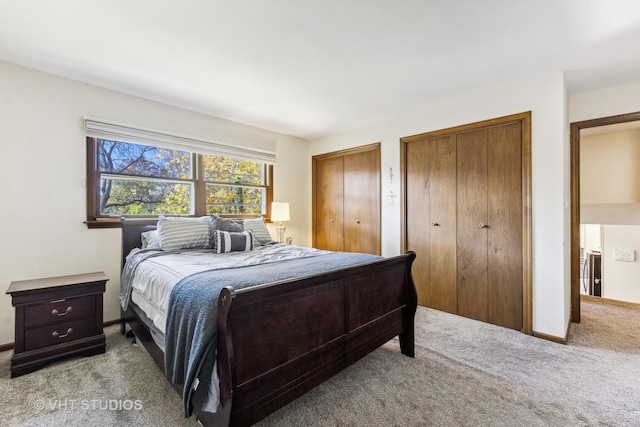 carpeted bedroom with multiple closets and baseboards