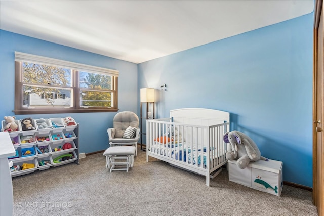 bedroom featuring a crib, carpet flooring, and baseboards