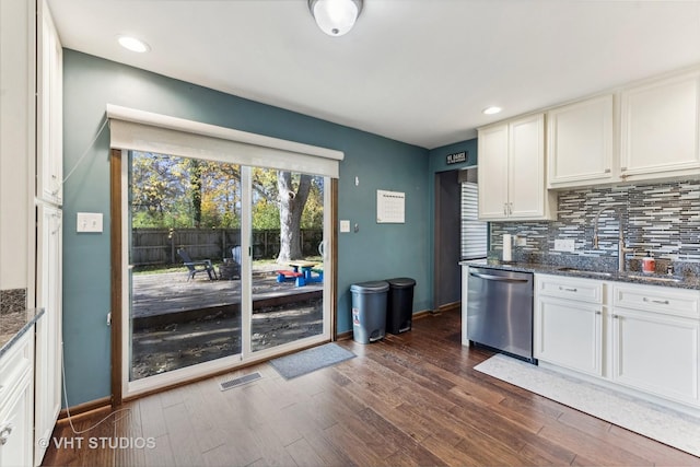 kitchen with decorative backsplash, dark wood-style flooring, a sink, and stainless steel dishwasher