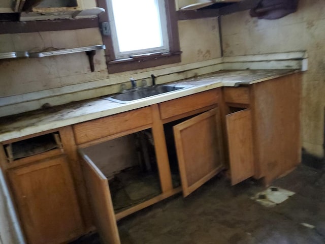 kitchen featuring light countertops, a sink, and brown cabinets