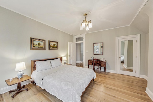 bedroom with baseboards, light wood finished floors, and an inviting chandelier