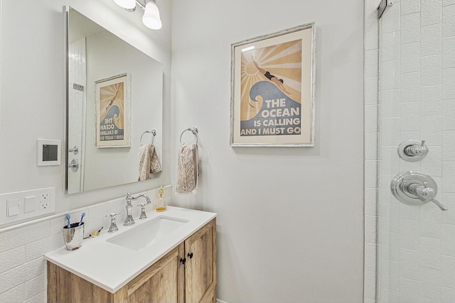 bathroom with tiled shower and vanity