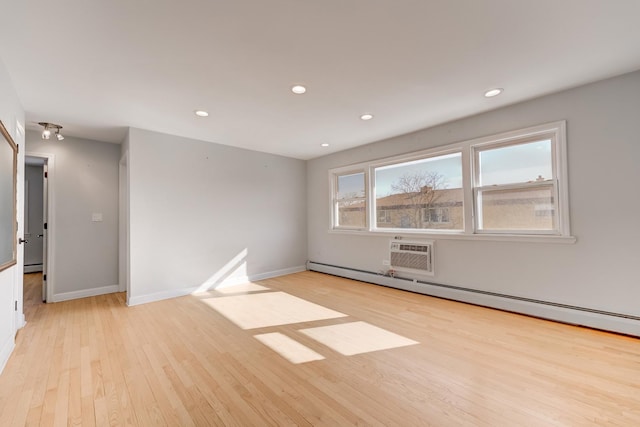 empty room featuring recessed lighting, baseboards, a baseboard heating unit, and light wood-style floors