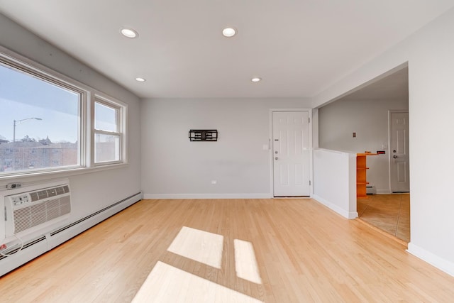 empty room featuring light wood-style flooring, recessed lighting, baseboards, and baseboard heating