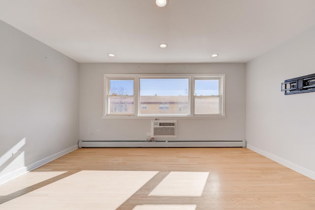 empty room with light wood-style flooring, recessed lighting, baseboards, and a wall mounted air conditioner