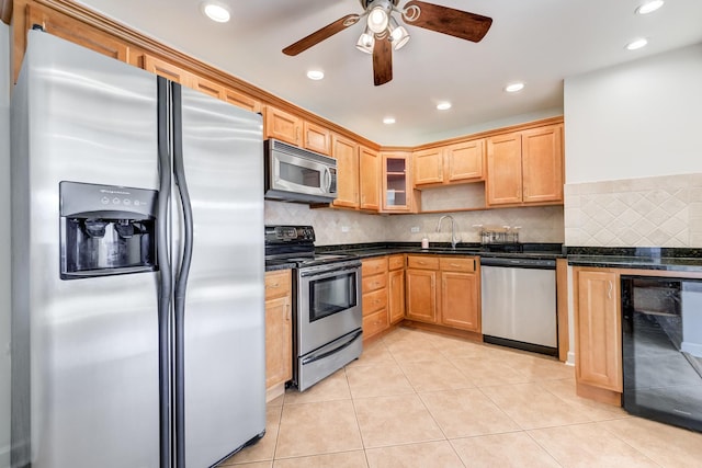 kitchen with light tile patterned floors, beverage cooler, a sink, appliances with stainless steel finishes, and backsplash