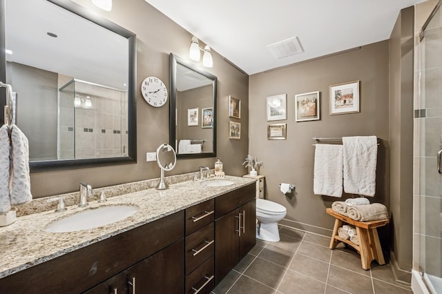 bathroom featuring tile patterned floors, visible vents, a stall shower, and a sink