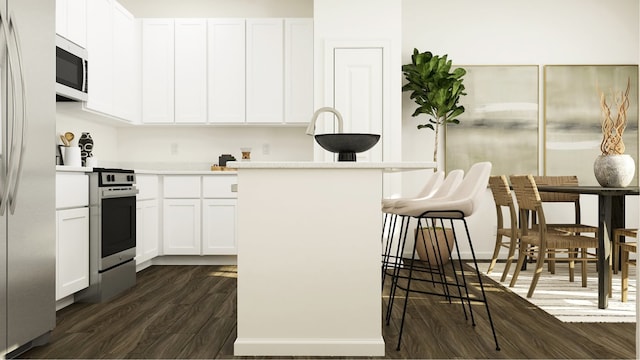 kitchen featuring stainless steel range with gas cooktop, light countertops, white microwave, dark wood-type flooring, and a kitchen bar