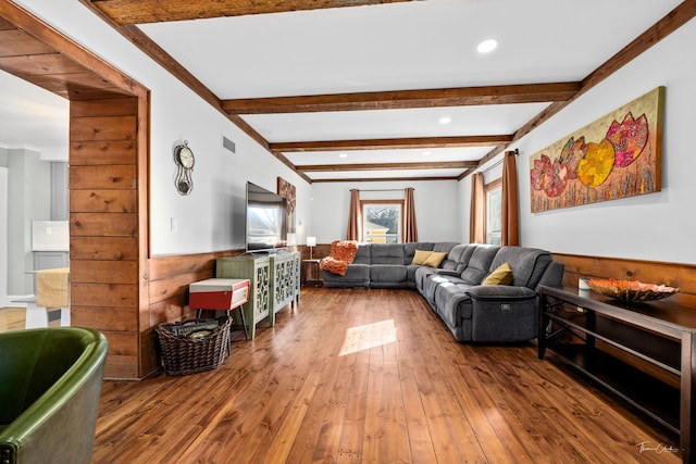 living room with wainscoting, beamed ceiling, visible vents, and hardwood / wood-style floors