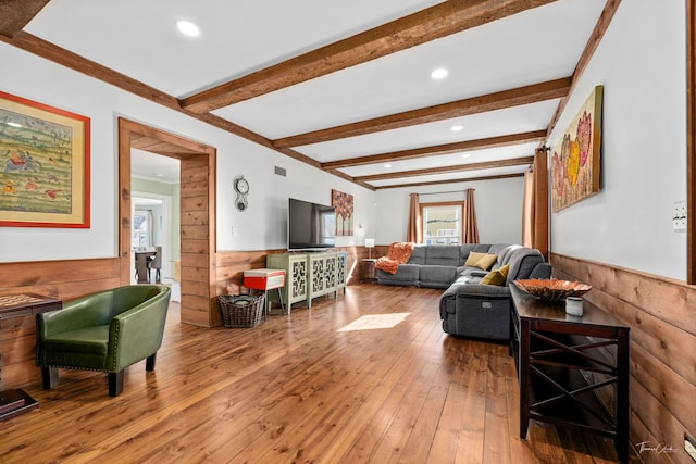 living room with wainscoting, beamed ceiling, wood walls, light wood-style floors, and recessed lighting