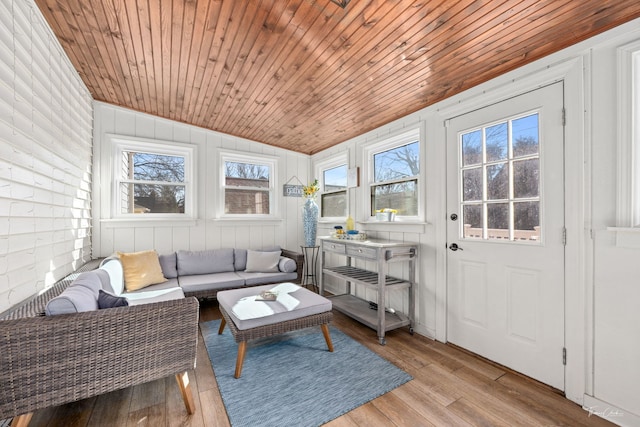 sunroom featuring lofted ceiling, wooden ceiling, and a wealth of natural light