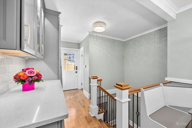 interior space featuring light wood finished floors, baseboards, and ornamental molding