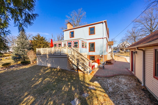 back of house with a patio, a chimney, stairs, a deck, and a yard