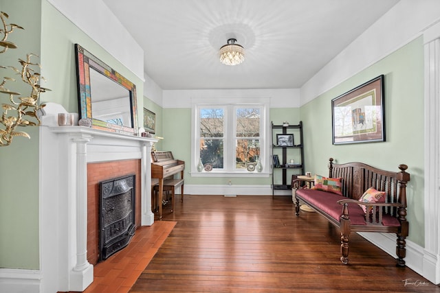 living area with a fireplace with flush hearth, baseboards, and hardwood / wood-style floors