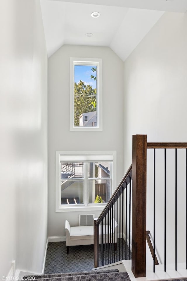 stairs with carpet floors, lofted ceiling, and baseboards