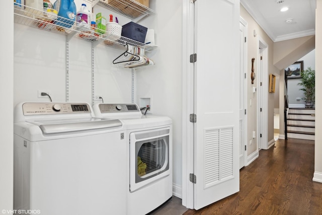 clothes washing area with laundry area, baseboards, dark wood-style floors, ornamental molding, and washer and dryer